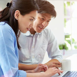 Un couple asiatique regarde sur leur ordinateur portable
